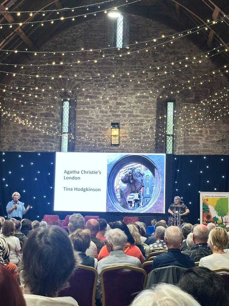 Tina Hodgkinson being introduce at the start of her Agatha Christie's London talk inside the Spanish Barn